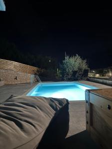 a swimming pool at night with a bed next to it at Villa Maria in Stalos +47 photos