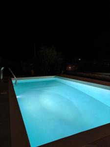 a swimming pool lit up at night at Villa Maria in Stalos