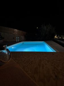 a swimming pool at night with a table and a chair at Villa Maria in Stalos