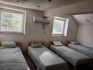 3 camas en una habitación con 2 ventanas en Belgrade Hostel Shambala, en Belgrado