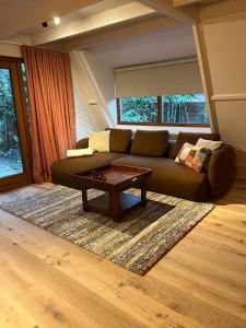 a living room with a couch and a coffee table at Boshuisje Rekem - Sylva in Lanaken