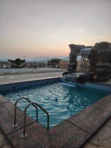 a swimming pool with a water slide in it at كهف الريف Reef Cave in Al Ḩamrāʼ