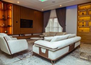 a living room with a couch and two chairs at Mthree residence and apartment Ltd in Abuja