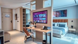 Un dormitorio con una cama y un escritorio con una computadora. en MH HOTEL Nouakchott, en Nouakchott