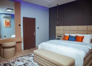 a bedroom with a large white bed with orange pillows at Mthree residence and apartment Ltd in Abuja
