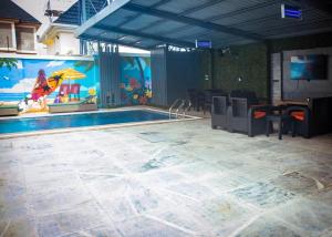 a swimming pool with a table and chairs and a mural at Mthree residence and apartment Ltd in Abuja