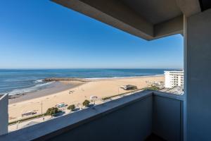 a view of the beach from the balcony of a building at Hotel Apartamento Solverde in Espinho
