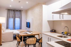 a kitchen and living room with a table and chairs at Aparthotel Rambla108 in Barcelona