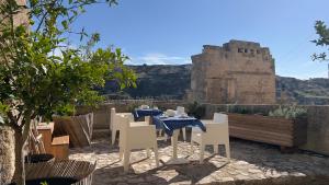 een tafel en stoelen met een kasteel op de achtergrond bij Il Carrubo residenza Walk&Stay in Matera