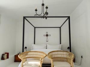 a bedroom with a bed with two rattan chairs at Stay at Richmond in Richmond