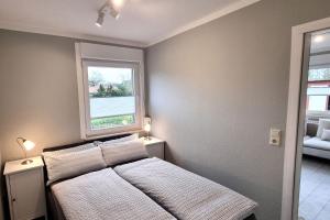 a bedroom with a bed and a window at Haus Spökenkieker in Borkum