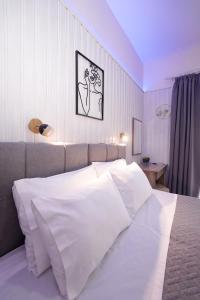a bedroom with a large bed with white sheets at Ipsos Wave Apartments in Ipsos