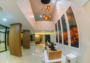 a lobby of a hotel with paintings on the walls at Hotel Rochedo, Penedo - Alagoas in Penedo
