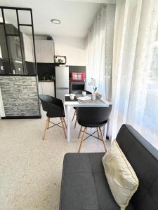 a living room with a couch and a table and chairs at Large Studio with sleeping area in Carnon-Plage