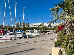 a marina with boats and a building in the background at Large Studio with sleeping area in Carnon-Plage