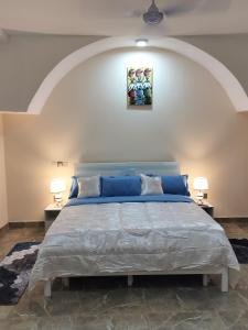 een slaapkamer met een groot bed en twee lampen bij Modern 1 bedroom flats in Tema