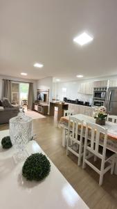 una cucina e un soggiorno con tavolo e sedie di Apto Flor Três Marias-2 Quartos- Apto todo climatizado- Moderno, confortável, à 150m do Parque Termal a Piratuba