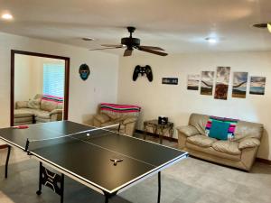 a living room with a ping pong table and couches at Spacious Arcade Table Tennis Game Room Cowboy Pool Near Tx Motor Speedwayby Vacation Your Way in Fort Worth +28 photos