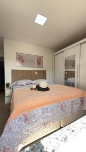 una camera da letto con un grande letto con un cappello sopra di Apto Flor Três Marias-2 Quartos- Apto todo climatizado- Moderno, confortável, à 150m do Parque Termal a Piratuba Altre 13 foto