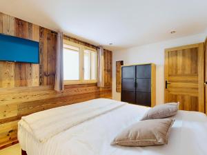 a bedroom with a large bed with wooden walls at Chalet 5* avec spa, sauna et jacuzzi pour 15 pers., accès pistes - FR-1-267-310 in Villarembert