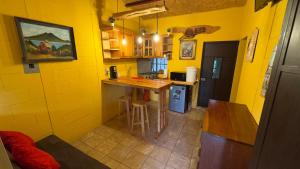 una pequeña cocina con paredes amarillas y encimera en Villa Josefina, en Santiago Sacatepéquez 9 fotos más