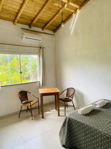 een slaapkamer met een tafel en 2 stoelen en een raam bij Lá no Rancho Trancoso in Trancoso