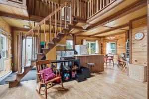 a living room with a staircase in a house at The Tiny Cozy Retreat in Saint-Just-de-Bretenières