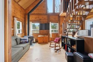 a living room with a couch and a staircase in a house at The Tiny Cozy Retreat in Saint-Just-de-Bretenières