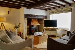 a living room with two couches and a fireplace at Nikolaus Cottage Cotswolds in Winchcombe