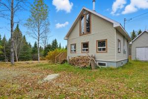 a house with a pile of wood in the yard at The Tiny Cozy Retreat in Saint-Just-de-Bretenières