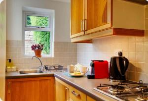 a kitchen with a sink and a counter top at Nikolaus Cottage Cotswolds in Winchcombe +9 photos