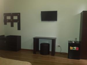 a room with a table and a tv on a wall at Inn Rif in Gagra
