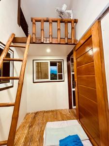 a room with a bunk bed and a ladder at TeamV Kubo Guesthouse in Agdañgan +8 photos