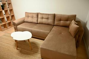 a living room with a brown couch and a table at Hanan Apartmani in Novi Pazar