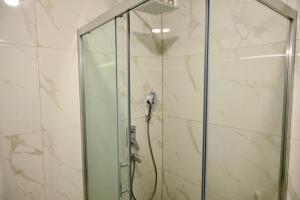 a shower with a glass door in a bathroom at Hanan Apartmani in Novi Pazar