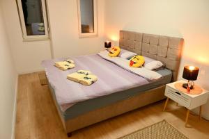 a bedroom with a bed with yellow pillows on it at Hanan Apartmani in Novi Pazar +30 photos