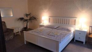 a bedroom with a white bed with two tables and two lamps at Mini Apart Hotel Abraka in Český Krumlov +58 photos