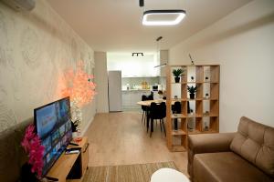 a living room with a couch and a dining room at Hanan Apartmani in Novi Pazar