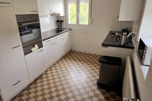 a kitchen with white cabinets and a tile floor at Helle, gemütliche Wohnung an der grenze vom Deutschland in Koblenz