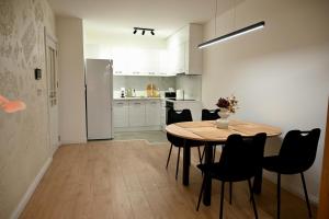 a kitchen with a table and chairs and a refrigerator at Hanan Apartmani in Novi Pazar +30 photos