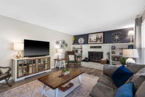 un salon avec un canapé et une télévision dans l'établissement Branson Downtown Beauty - 4 BDR Home Sleeps 15, à Branson