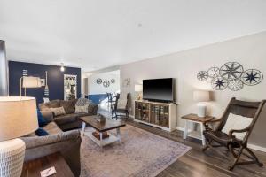 un salon avec un canapé et une télévision dans l'établissement Branson Downtown Beauty - 4 BDR Home Sleeps 15, à Branson