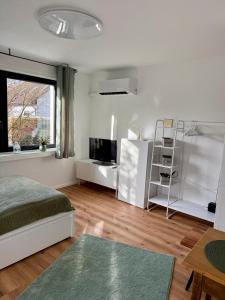 a bedroom with a bed and a tv and a window at Grüne Oase in Stadtnähe in Unna
