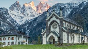 a large building in front of a mountain at Rifugio TEA Dolomiti in Caviola