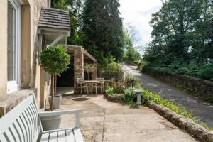 a white bench sitting on the side of a house at Cyclists Rest Matlock in Matlock