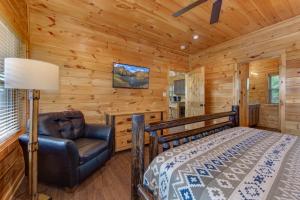 1 dormitorio con 1 cama y 1 silla en una cabaña en Majestic View, en Williamsburg