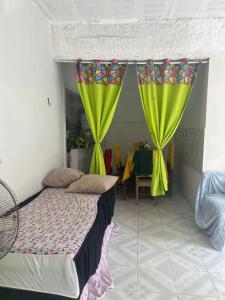 a bedroom with a bed with green curtains and a table at Casa de Elvira in Belém +4 photos