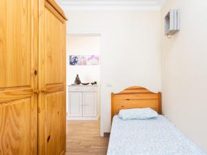 ein kleines Schlafzimmer mit einem Bett und einem Holzschrank in der Unterkunft Live La Caleta Mar de plata 14 in Caleta de Interián