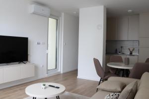 a living room with a couch and a tv and a table at Il sogno apartman in Vranješ