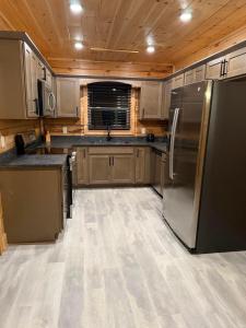 Una cocina con electrodomésticos de acero inoxidable y gabinetes de madera. en Savannah Smiles, en Williamsburg